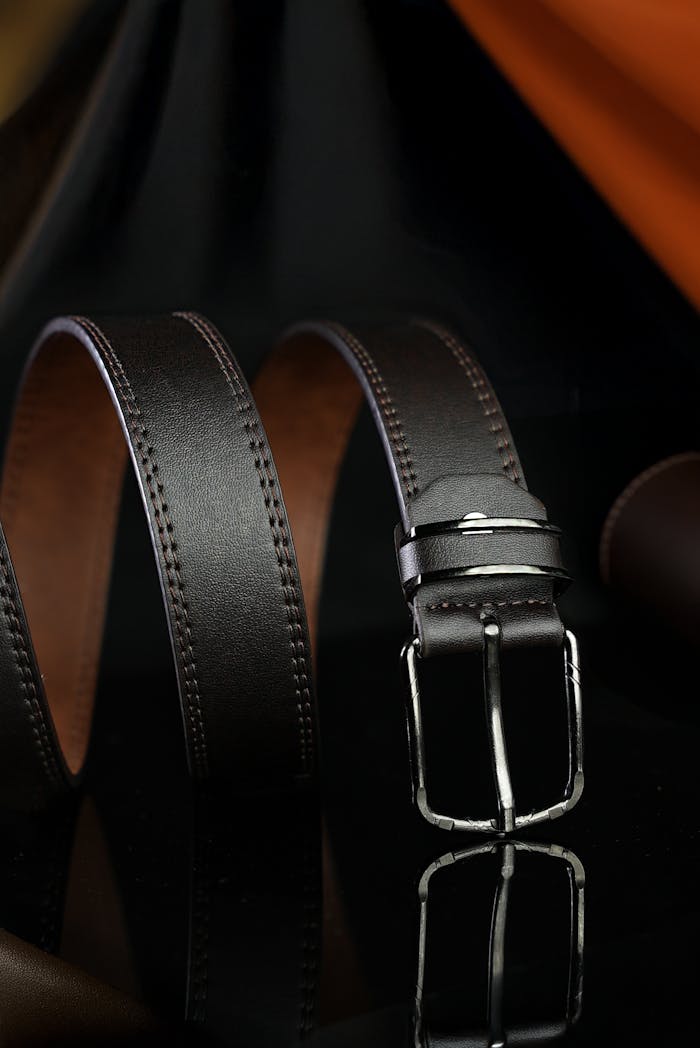Elegant leather belt with metallic buckle, showcasing high-end fashion design.